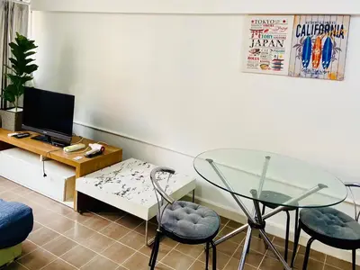 a living room with a glass table and chairs at Impact Arena Condo 2Rooms C3 by GoodRoom24 in Ban Bang Phang