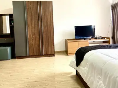 a hotel room with a bed and a television at Impact Arena Condo 10fl by GoodRoom24 in Ban Song Hong