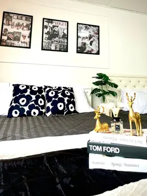 a bedroom with a bed with four pictures on the wall at Impact Arena Condo Twin Beds by Goodroom24 in Ban Song Hong