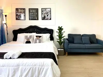 a bedroom with a bed and a blue couch at Impact Arena Condo 6fl by GoodRoom24 in Ban Song Hong