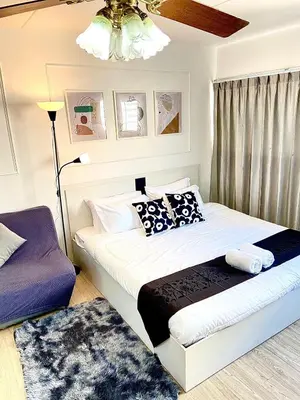 a bedroom with a bed and a lamp at Impact Arena C8 Condo by GoodRoom24 in Thung Si Kan