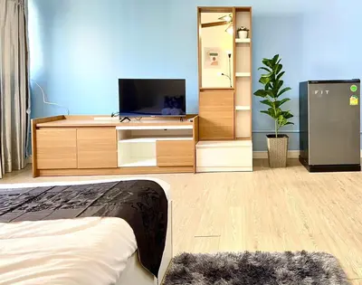a living room with a tv and a bed at Impact Arena C8 Condo by GoodRoom24 in Thung Si Kan