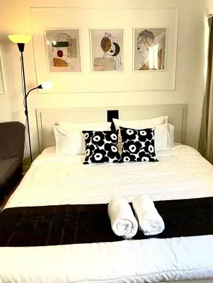 a bedroom with a bed with black and white pillows at Impact Arena C8 Condo by GoodRoom24 in Thung Si Kan