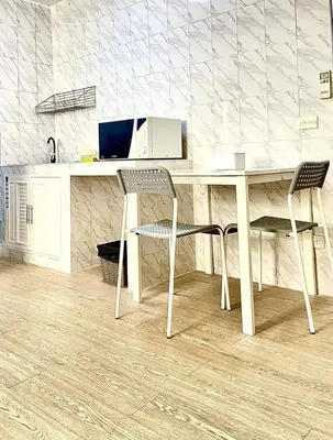 a desk with two chairs and a computer on it at Impact Arena C8 Condo by GoodRoom24 in Thung Si Kan