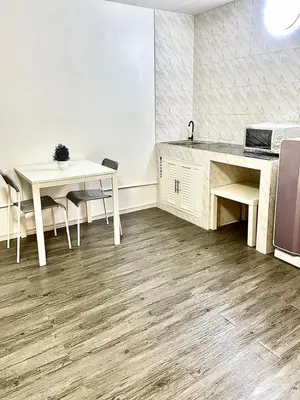 a kitchen with a table and a sink and a counter at Impact Arena Condo C3 Grey by GoodRoom24 in Ban Bang Phang