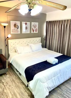 a bedroom with a large bed with white sheets at Impact Arena Condo C9 by GoodRoom24 in Pak Kret