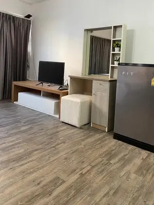 a room with a desk with a computer and a refrigerator at Impact Arena Condo C9 by GoodRoom24 in Pak Kret
