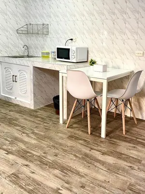 a kitchen with a table and two chairs and a microwave at Impact Arena Condo C9 by GoodRoom24 in Pak Kret