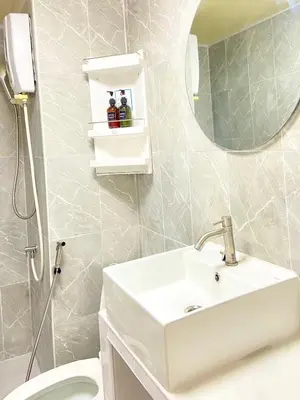 a bathroom with a sink and a mirror and a toilet at Impact Arena Condo The Classic by GoodRoom24 in Ban Song Hong