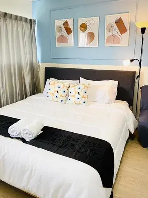 a bedroom with a bed with white sheets and pillows at Impact Arena Condo TwoTone By GoodRoom24 in Ban Song Hong