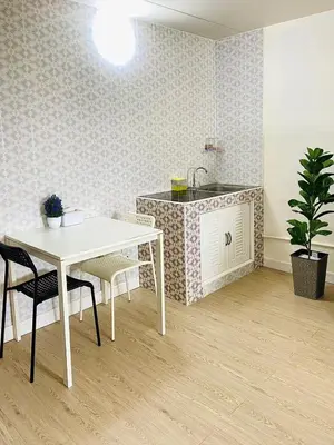 a kitchen with a table and chairs and a sink at Impact Arena Condo TwoTone By GoodRoom24 in Ban Song Hong