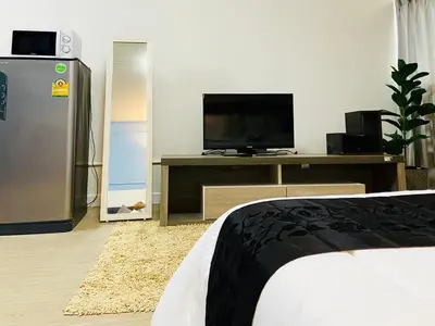a bedroom with a bed and a tv on a table at Impact Arena Condo TwoTone By GoodRoom24 in Ban Song Hong