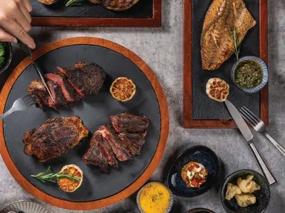 a table with a plate of meat and other foods at Four Points by Sheraton Bangkok, Sukhumvit 22 in Bangkok
