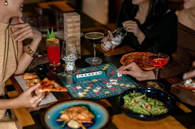 a group of people sitting around a table playing a board game at Four Points by Sheraton Bangkok, Sukhumvit 22 in Bangkok