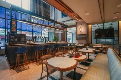 a restaurant with tables and chairs and a bar at Four Points by Sheraton Bangkok, Sukhumvit 22 in Bangkok