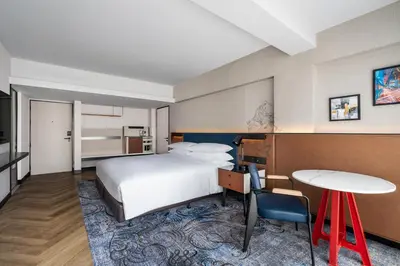 a hotel room with a bed and a desk and a table at Four Points by Sheraton Bangkok, Sukhumvit 22 in Bangkok