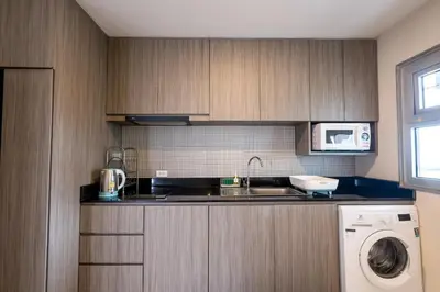 a kitchen with a sink and a washing machine at Spacious 3BR near Impact, Don Mueang Airport & Pink Line MRT in Nonthaburi