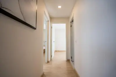 a hallway of a house with white walls at Spacious 3BR near Impact, Don Mueang Airport & Pink Line MRT in Nonthaburi