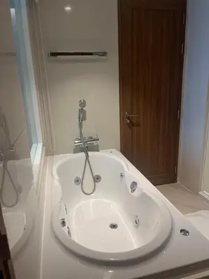 a bathroom with a bath tub with a sink at Executive Apartment Thonglor in Bangkok