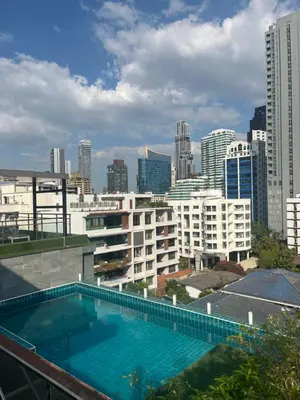 a swimming pool on the roof of a building with a city at Executive Apartment Thonglor in Bangkok