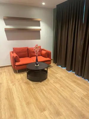 a living room with a red couch and a table at Executive Apartment Thonglor in Bangkok