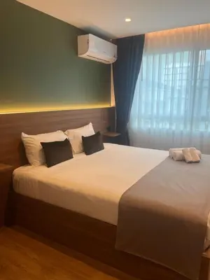 a hotel room with two beds and a window at Executive Apartment Thonglor in Bangkok