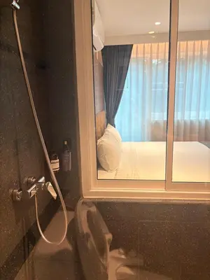 a bathroom with a window with a bed in it at Apartment in Central Sukhumvit in Bangkok
