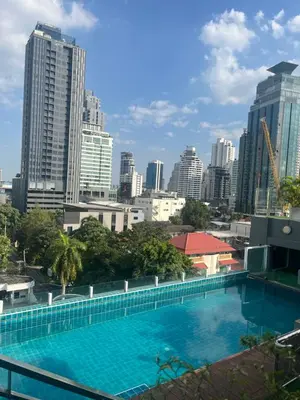 a large swimming pool with a city skyline in the background at Apartment in Central Sukhumvit in Bangkok