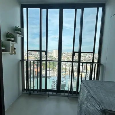 a room with a large window with a view of a city at Sukhumvit Bts ideomix1 in Amphoe Phra Khanong