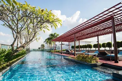 a pool at a resort with benches and trees at Sukhumvit Bts ideomix1 in Amphoe Phra Khanong
