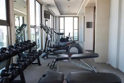 a gym with several treadmills and elliptical machines at Sukhumvit Bts ideomix1 in Amphoe Phra Khanong