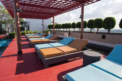 a row of lounge chairs on the roof of a building at Sukhumvit Bts ideomix1 in Amphoe Phra Khanong