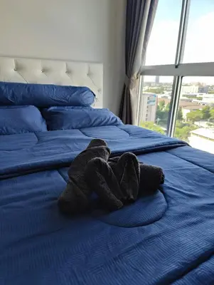 a stuffed teddy bear laying on a bed at Cozy Apartment Night Market and Shopping Mall at MRT Purple Line in Nonthaburi