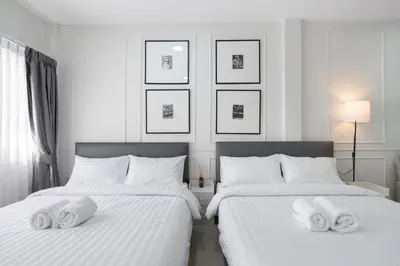 a bedroom with two beds with white pillows on them at Arun Sa wad - Chinatown in Bangkok