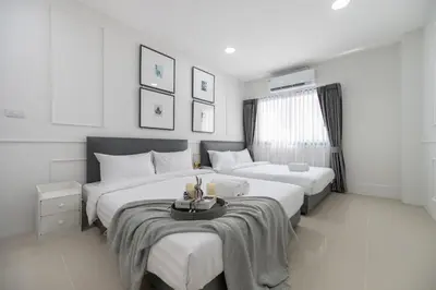 a bedroom with two beds and a table in it at Arun Sa wad - Chinatown in Bangkok