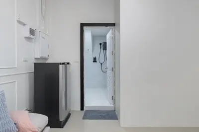a bathroom with a walk in shower next to a door at Arun Sa wad - Chinatown in Bangkok