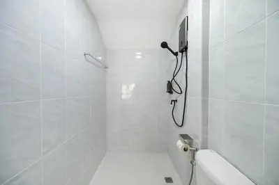 a white bathroom with a shower and a toilet at Arun Sa wad - Chinatown in Bangkok