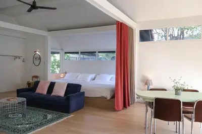 a bedroom with a bed and a blue couch and a table at House 33 in Bangkok