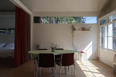 a dining room with a green table and chairs at House 33 in Bangkok