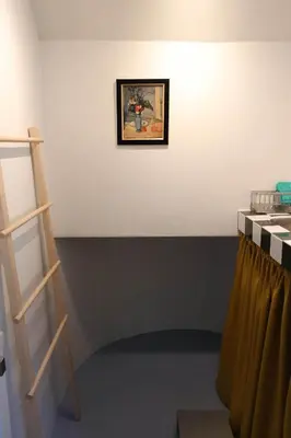a room with a ladder and a painting on the wall at House 33 in Bangkok