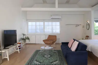 a living room with a blue couch and a bed at House 33 in Bangkok
