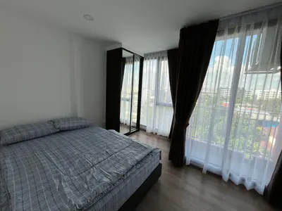 a bedroom with a bed and large windows at Cybiq Ratchada 32 By OBM in Ban Zong Katiam