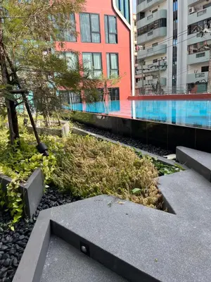 a garden in a city with a building at Cybiq Ratchada 32 By OBM in Ban Zong Katiam