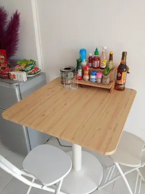a wooden table with two chairs and bottles on it at City villa condo - Cozy budget flat in LadPhao rd, Bangkapi in Ban Bang Toei (1)