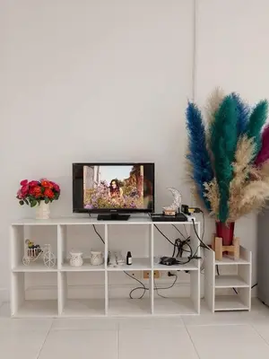 a living room with a tv on a white shelf at City villa condo - Cozy budget flat in LadPhao rd, Bangkapi in Ban Bang Toei (1)