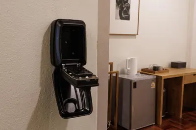 a cell phone holder on a wall next to a desk at baan nuit Bangkok Stayhouse in Bangkok