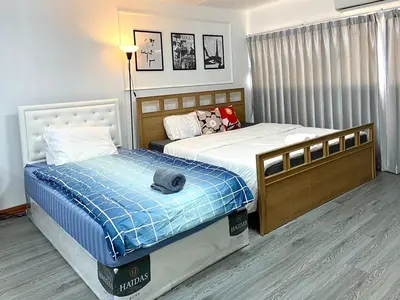 a bedroom with two beds and a dog laying on top at Impact Arena C3 Twin Beds By GoodRoom 24 in Ban Bang Phang