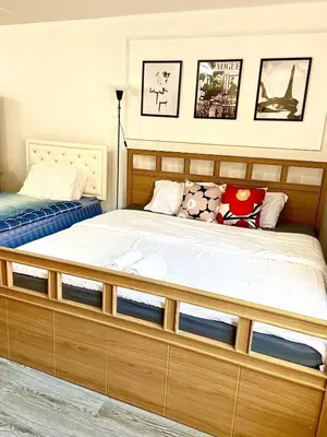 a bed with a wooden frame in a bedroom at Impact Arena C3 Twin Beds By GoodRoom 24 in Ban Bang Phang