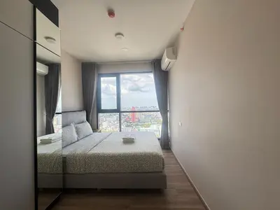 a bedroom with a bed and a large window at Neon Cloud Bangkok in Bangkok