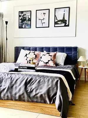 a bedroom with a bed with a blue headboard at Impact Arena C75fl by GoodRoom24 in Ban Song Hong